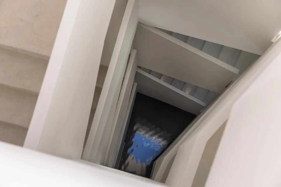 一座現代樓梯，採用混凝土踏步搭配玻璃扶手。