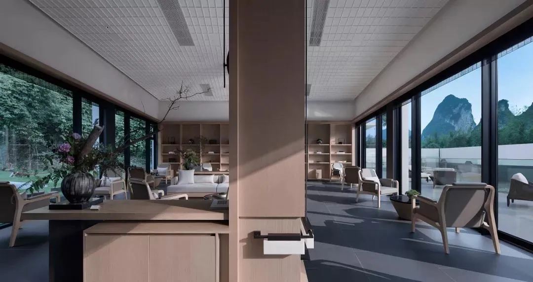 A modern living room featuring wood furniture, glass elements, and concrete flooring.