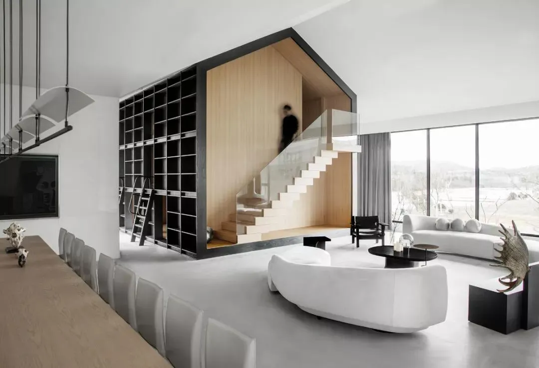 Modern living room with concrete floor, white furniture, and minimalist design