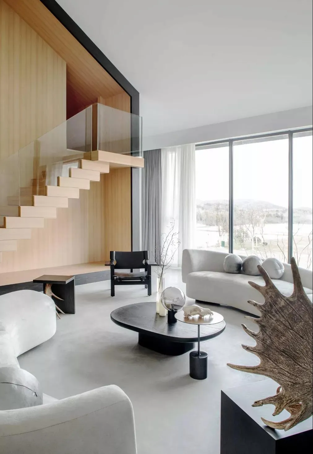 Modern, open-plan living room with white sofa and minimalist design.