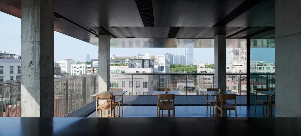 Modern rooftop restaurant with concrete and glass features