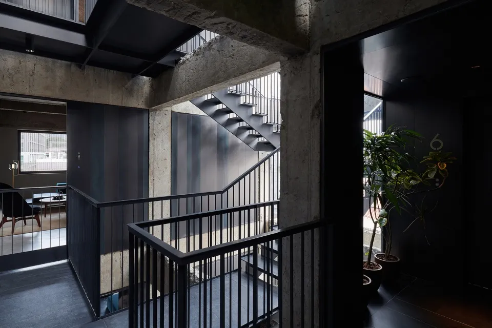 A minimalist interior with a modern metal railing and black elements.