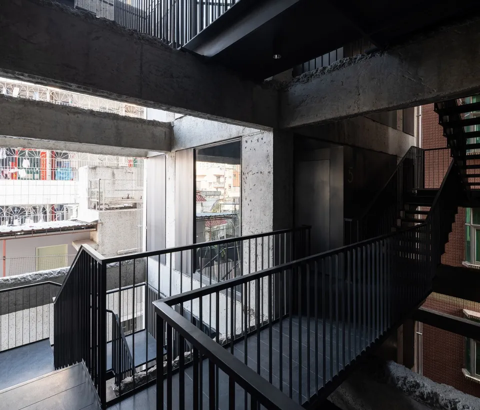 Modern industrial office space with concrete elements and a spiral staircase.