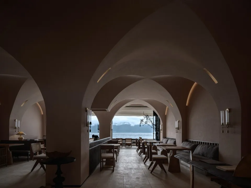 Modern coffee shop interior with wooden furniture and concrete walls.