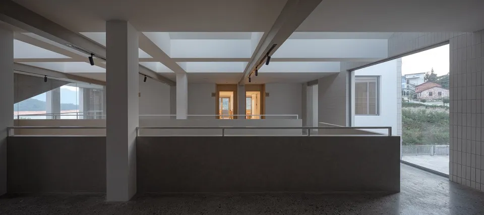 A modern lobby with concrete finishes and large glass panels.