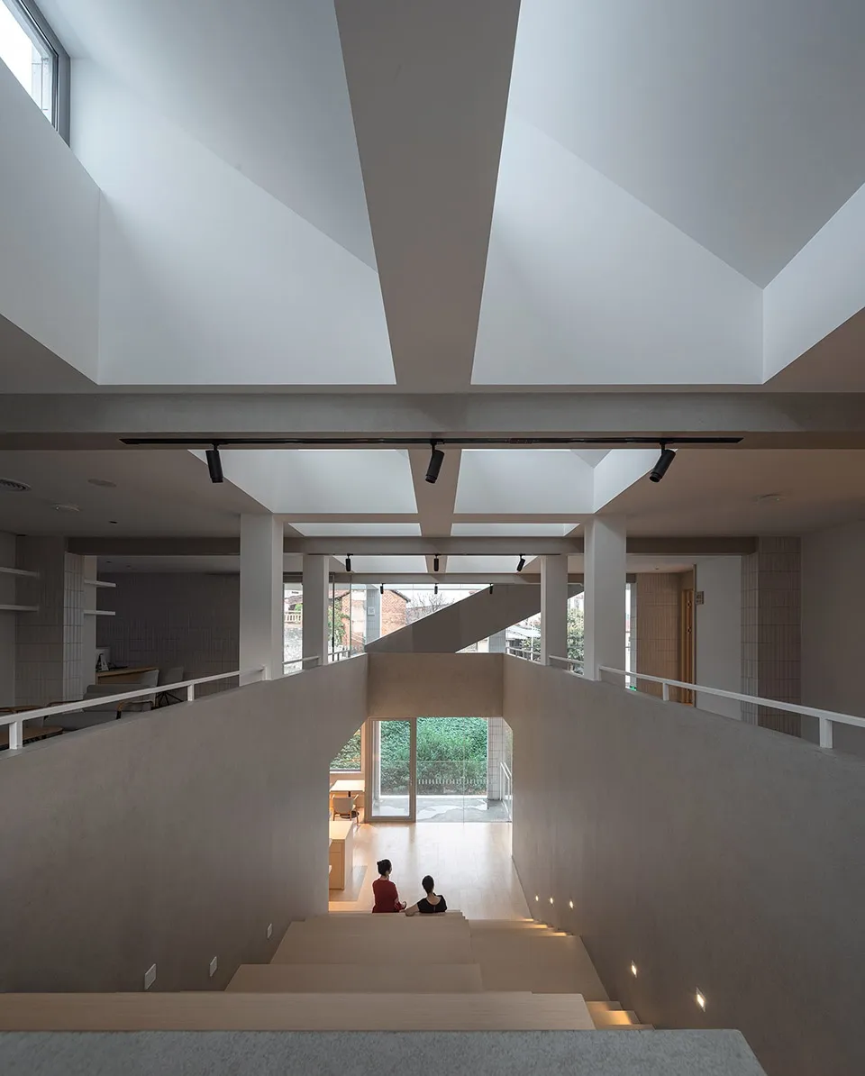 A modern living space with concrete walls and stairs, featuring a minimalist interior design.