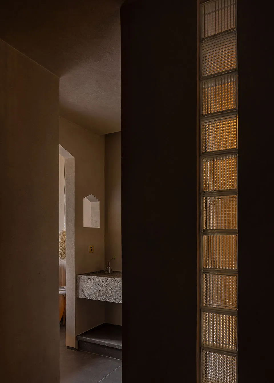 Modern residential space featuring architectural glass bricks and concrete elements.