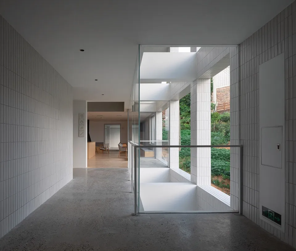 A modern office space featuring glass walls and concrete flooring.
