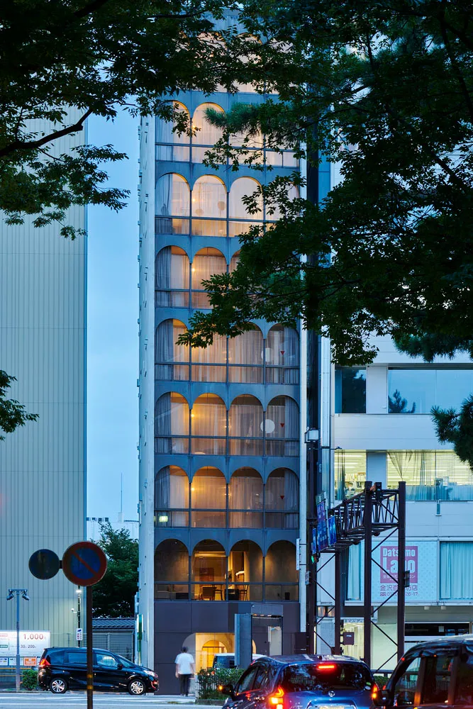 A modern building with glass exterior and arched windows.