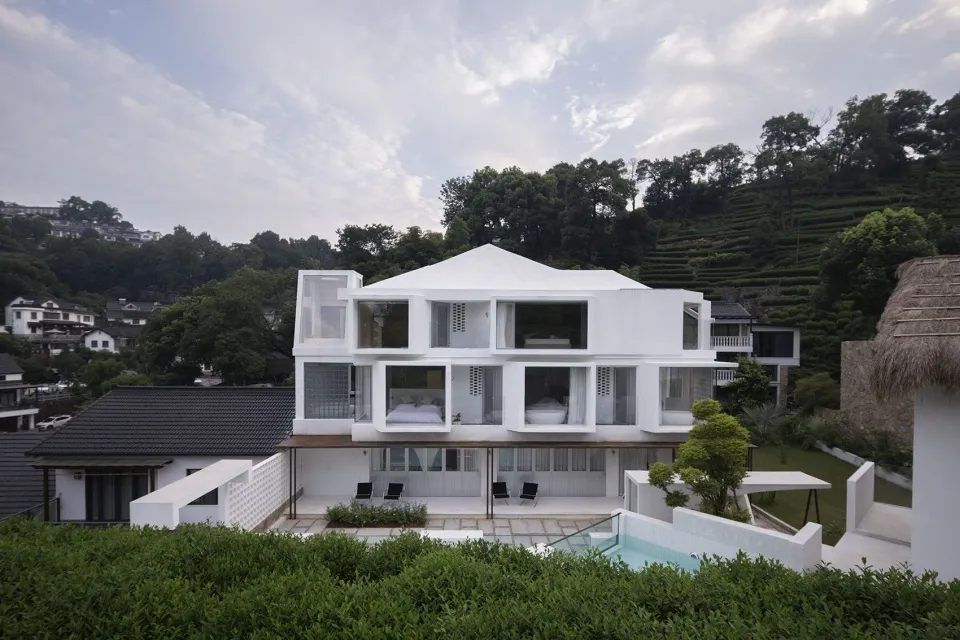 A modern house featuring glass walls, concrete floors, and wooden structures.