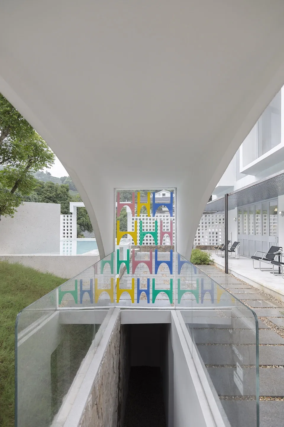 A modern glass interior space with colorful geometric shapes in the background.