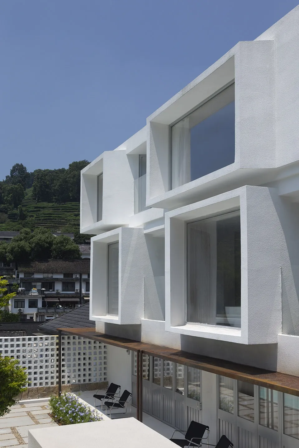 A modern residential house with a white exterior made of concrete.