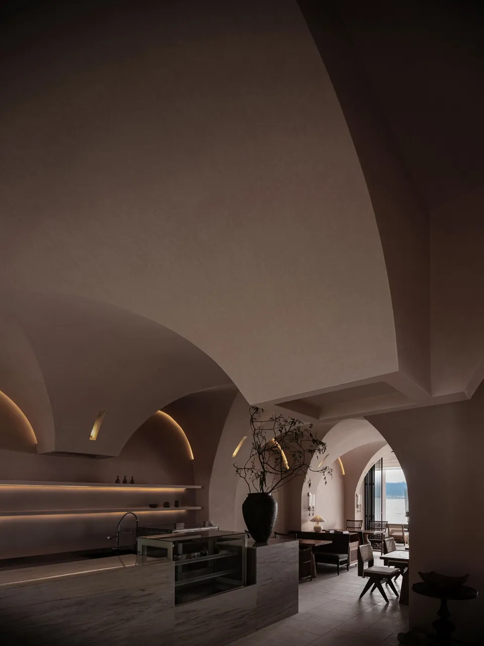 Interior design of a modern restaurant lobby with concrete walls and ambient lighting.