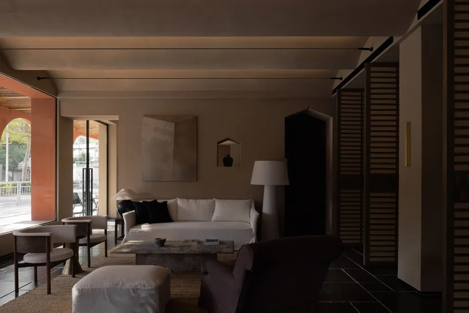 Modern, minimalist living room with neutral-toned furniture and decor.