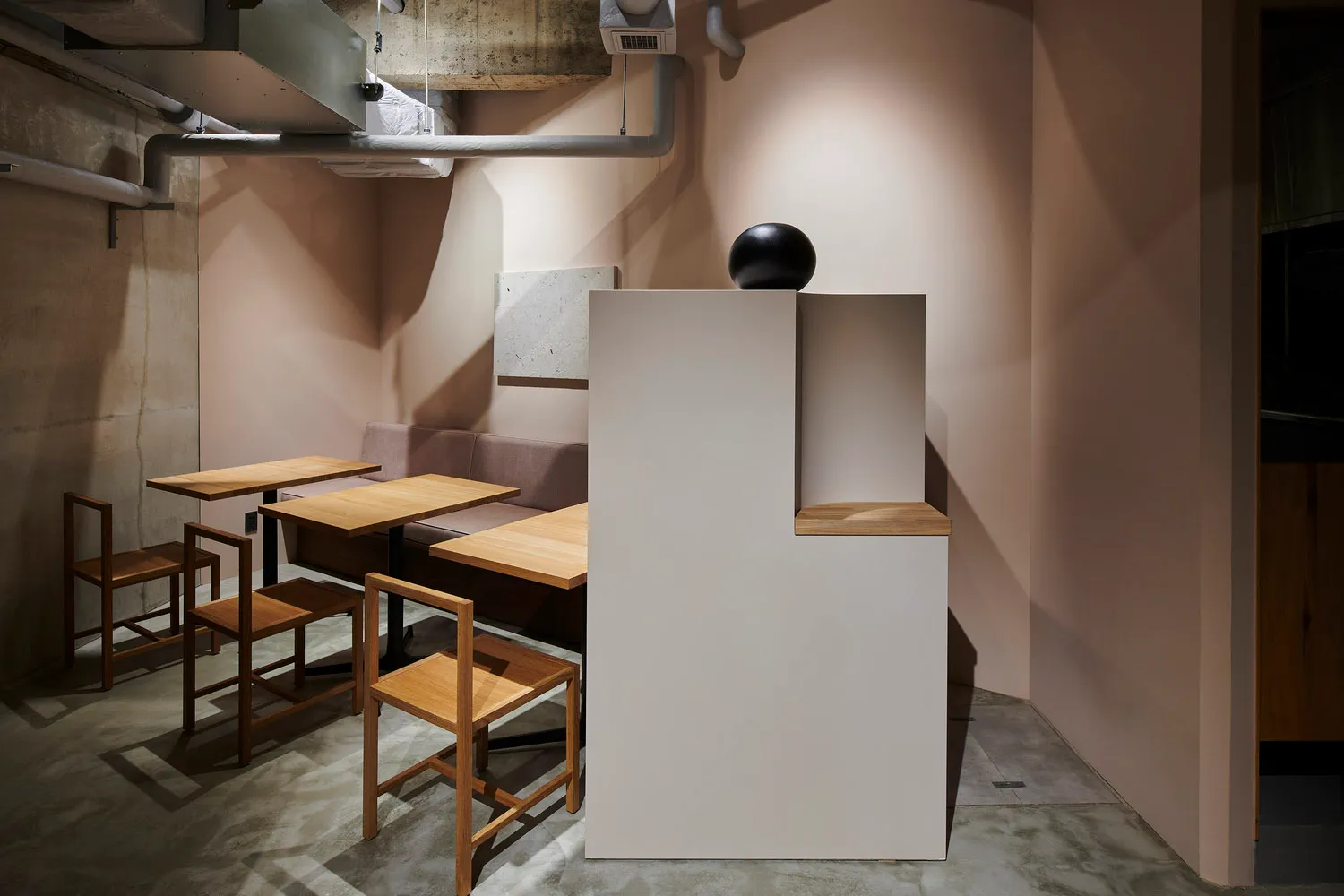 極簡風格的餐廳室內,搭配木質家具與混凝土牆面。