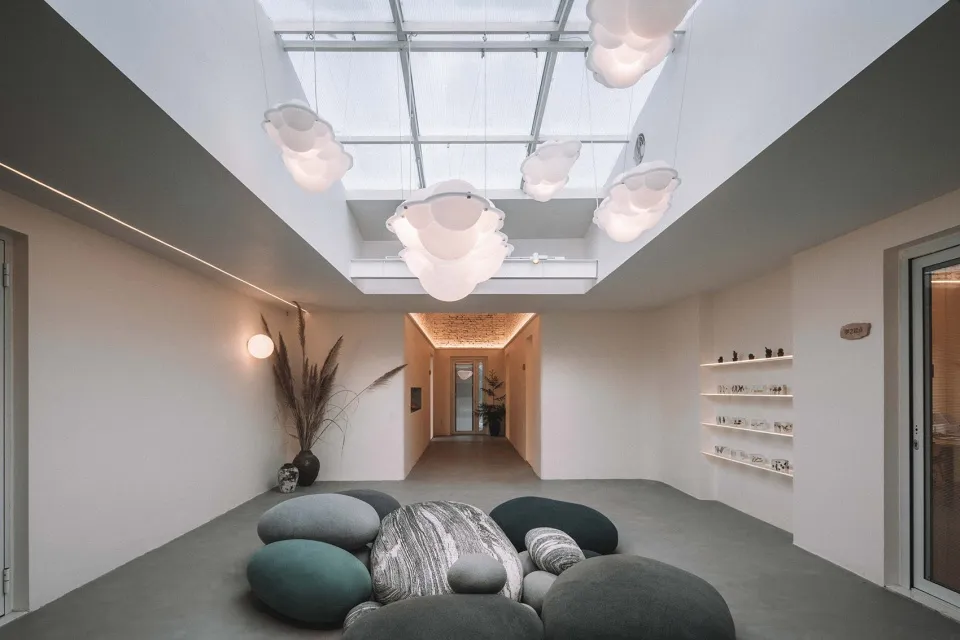 An industrial-style relaxation space with concrete flooring and oversized stone cushions.