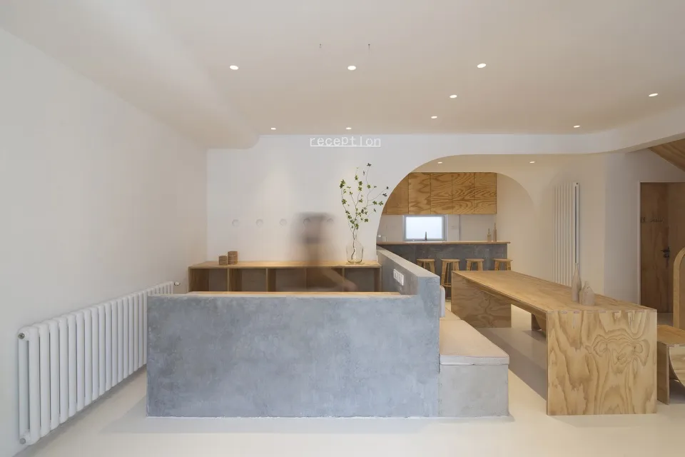 A minimalist coffee shop interior with wooden counters and seating.