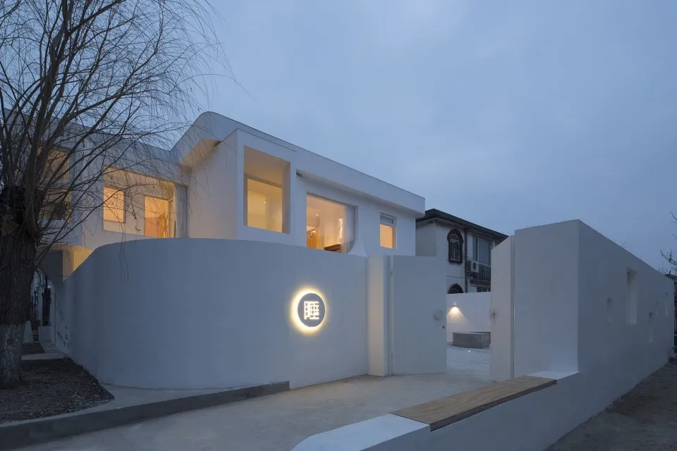 Modern home with a concrete exterior and warm indoor lighting during dusk