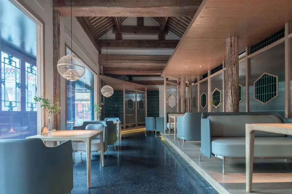 Contemporary seating and tables in a restaurant with modern design elements, including mixed materials and geometric shapes.
