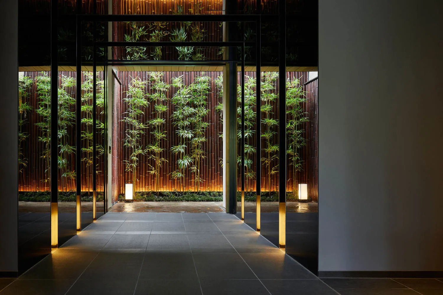 A minimalist modern corporate office entryway with glass walls and a concrete floor.