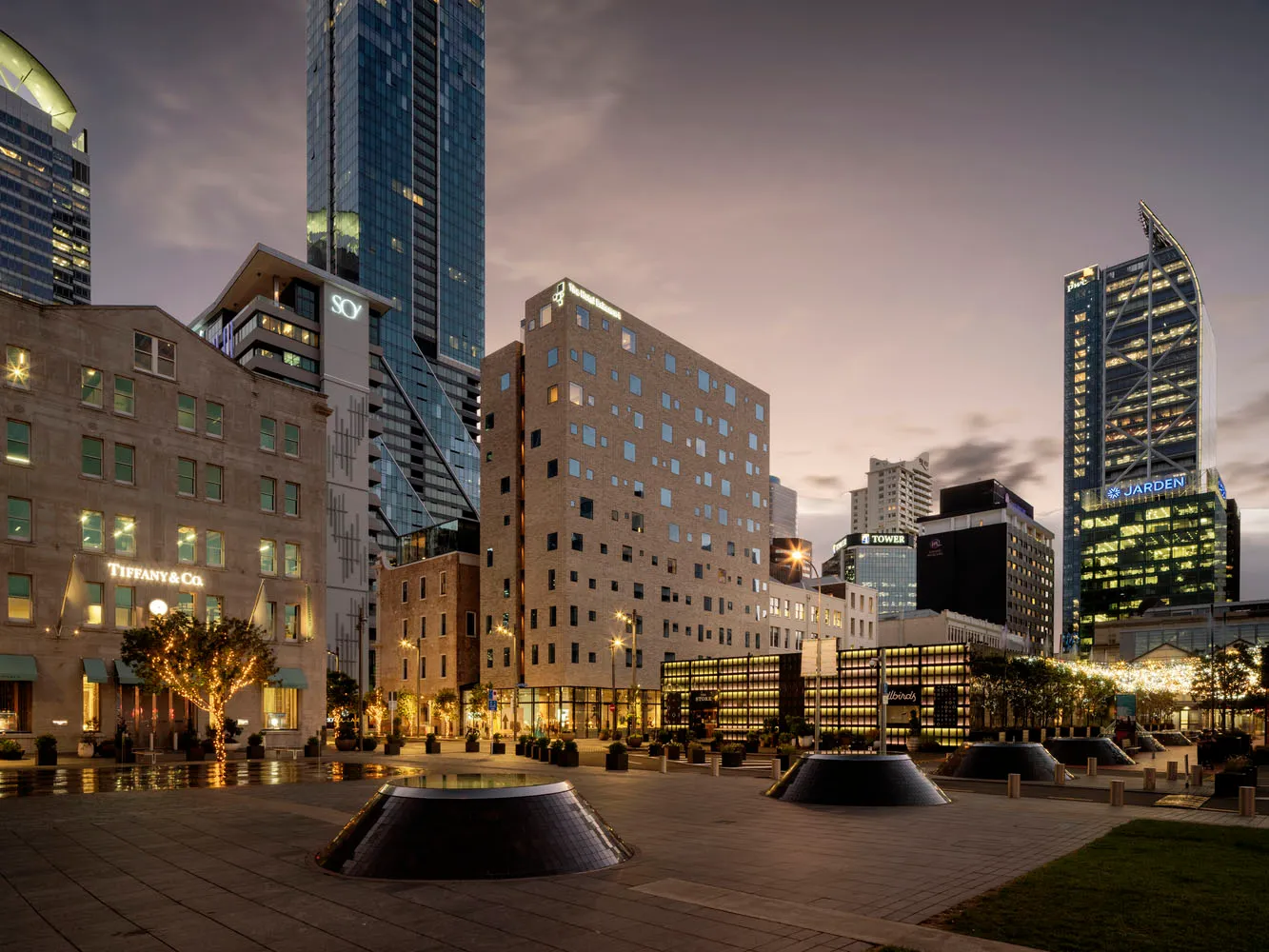 A modern cityscape featuring brick and glass buildings in an urban setting.