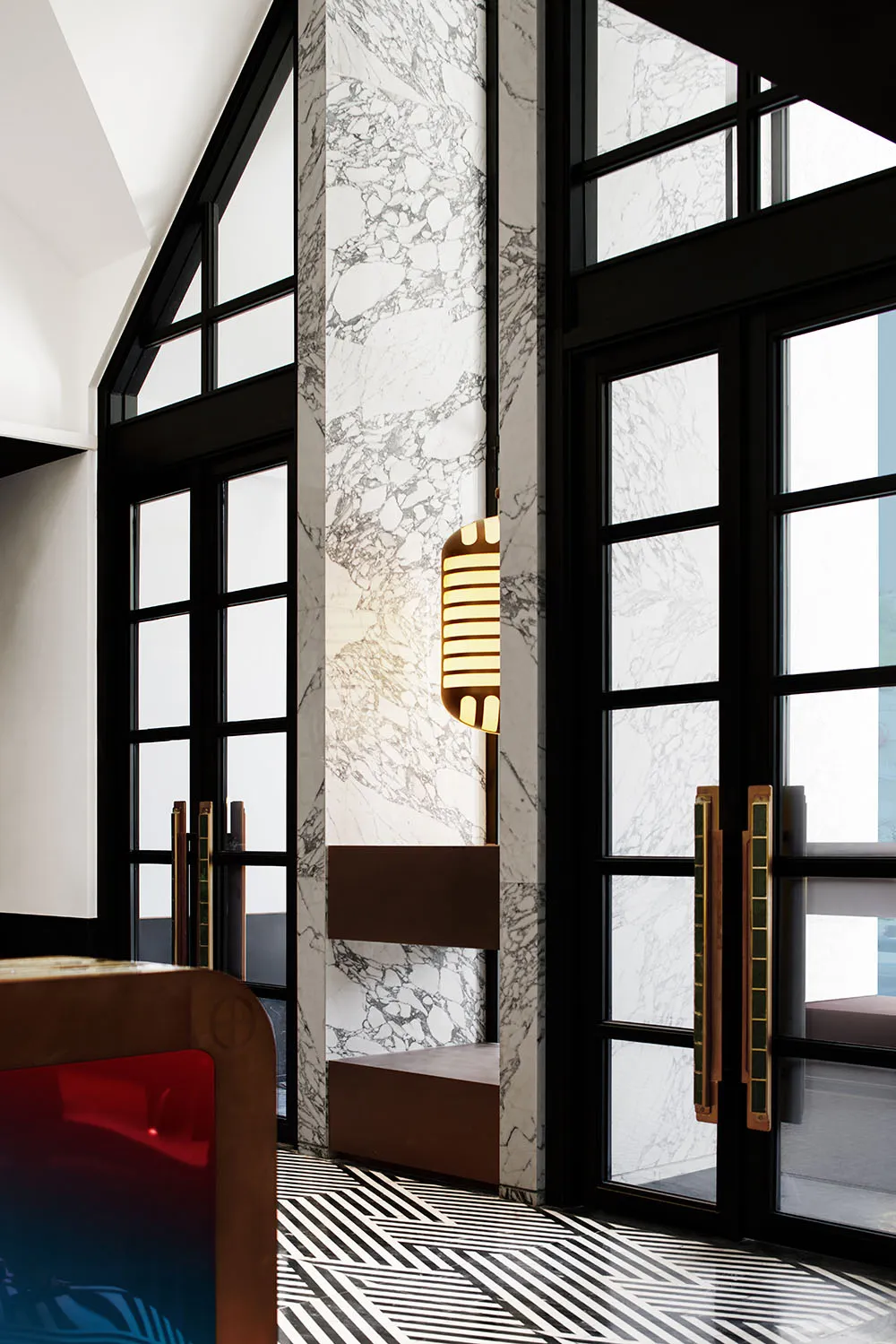 Modern entrance with marble columns and a hanging light fixture