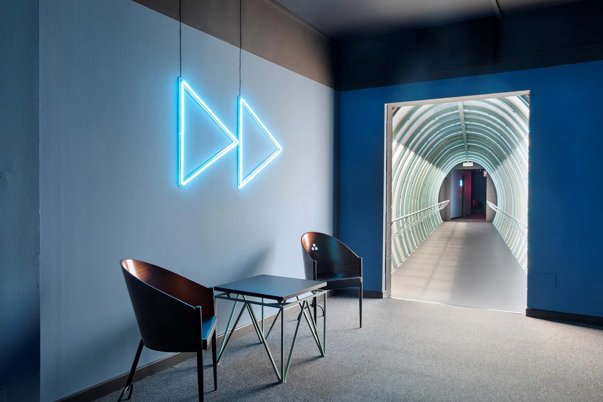 A minimalist corridor with metal railings and lighting features.
