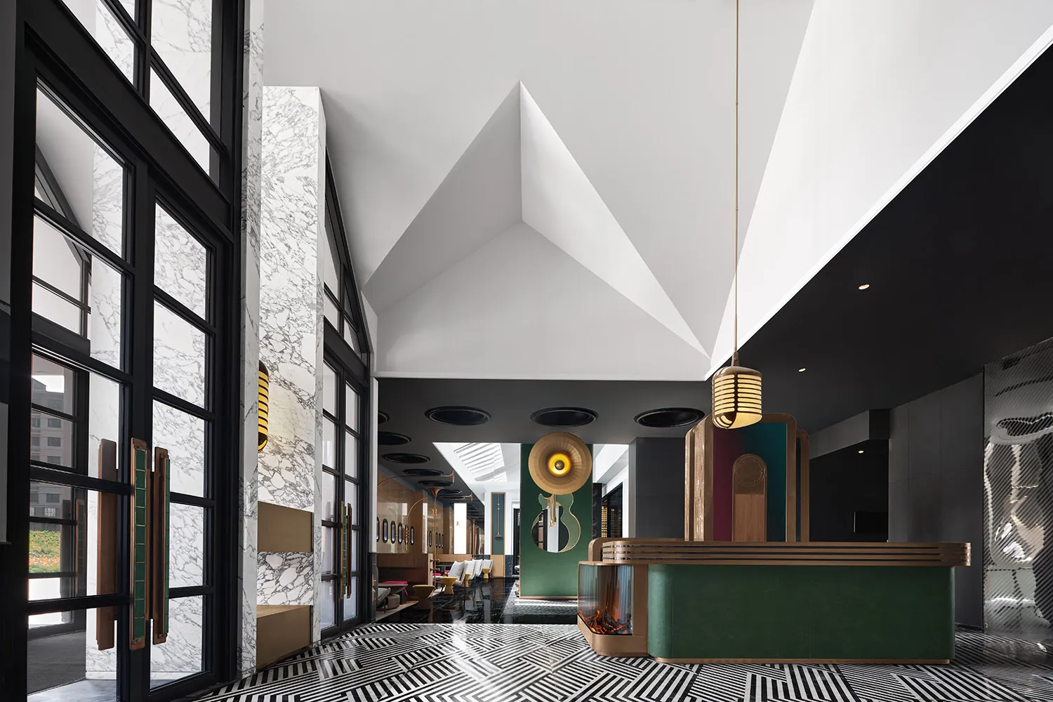 A modern lobby with marble walls, glass elements, metal accents, and wooden furniture.