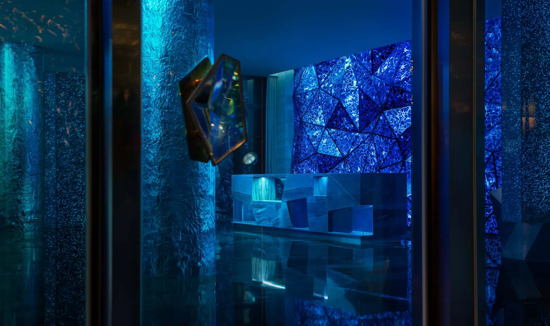 A minimalist hotel lobby featuring glass walls and geometric designs.