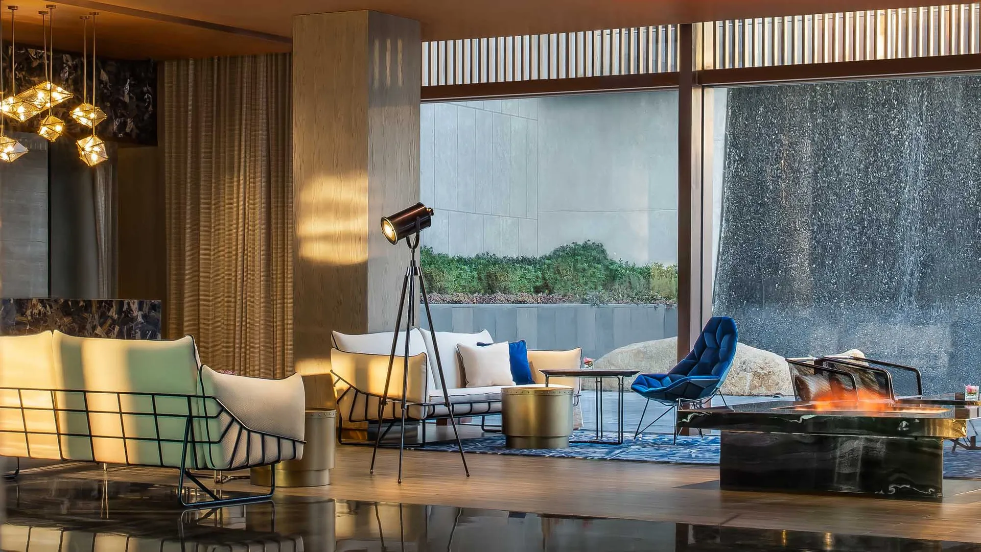 Modern living room with concrete floor, metal accents, and large windows.