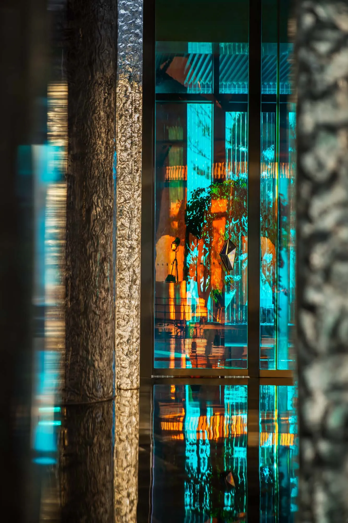 Modern retail store interior with large glass windows reflecting urban scenery and interior design elements.