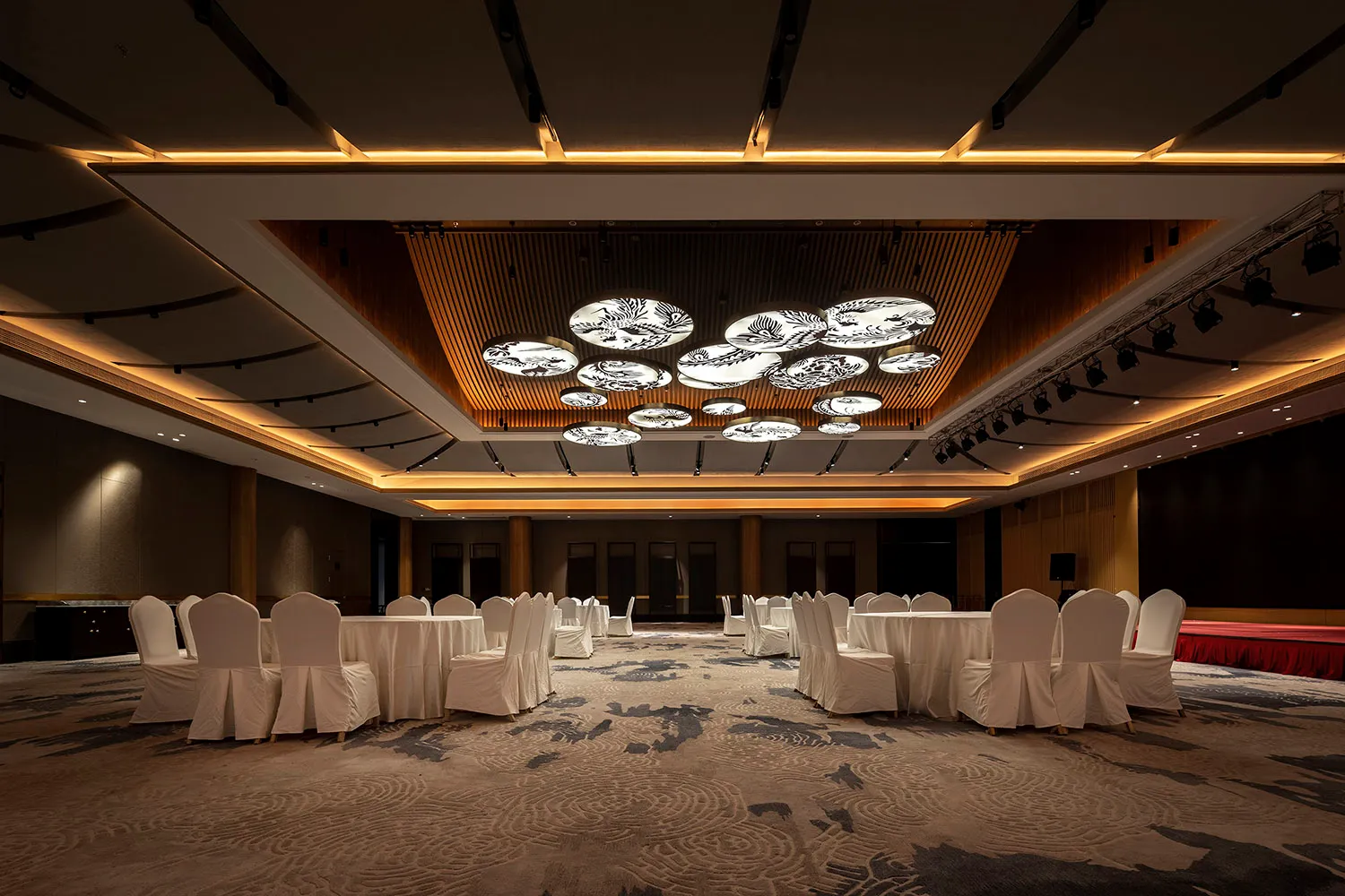 A conference room with tables and chairs covered in white cloth.