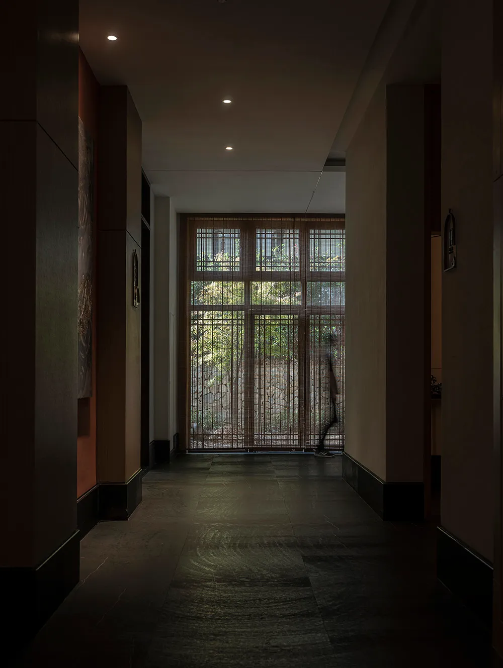 A modern interior design featuring glass elements and lighting in a corridor setting.