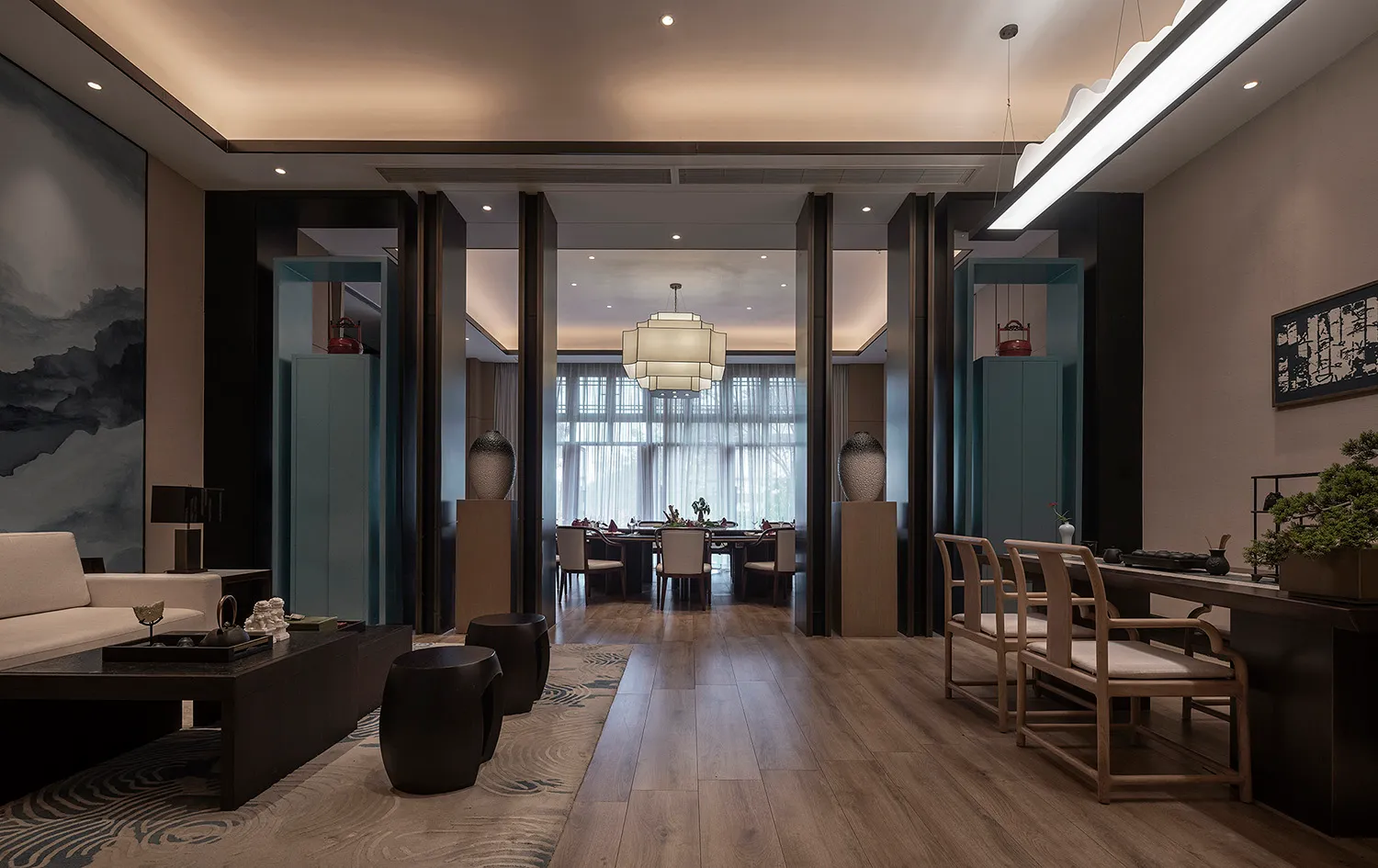 A modern living and dining room interior with wooden flooring, glass elements, and fabric seating.