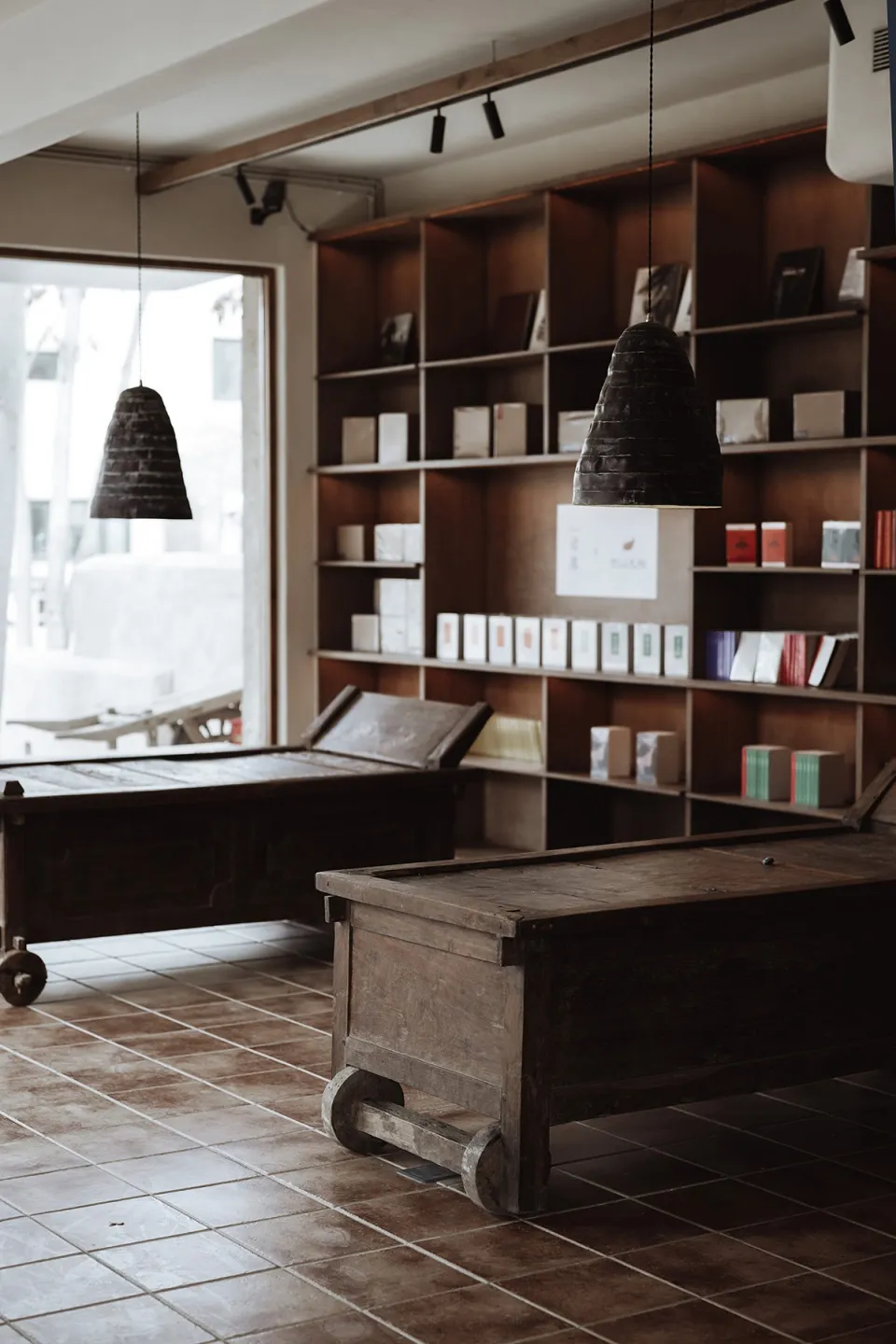 An industrial retail space featuring wooden furniture and shelves filled with books.