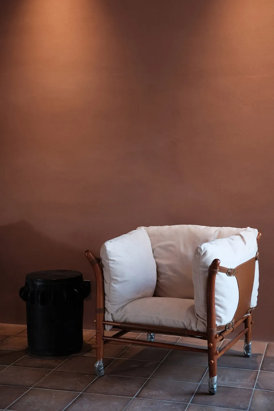 Tan leather and wooden frame armchair in a modern loft setting.