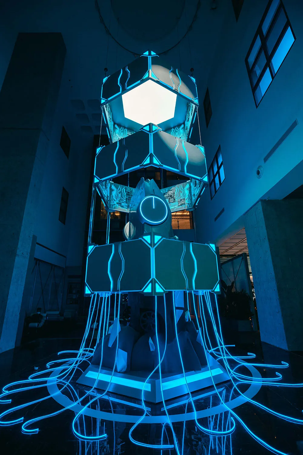 A futuristic industrial installation featuring aluminum, glass, and neon lights.