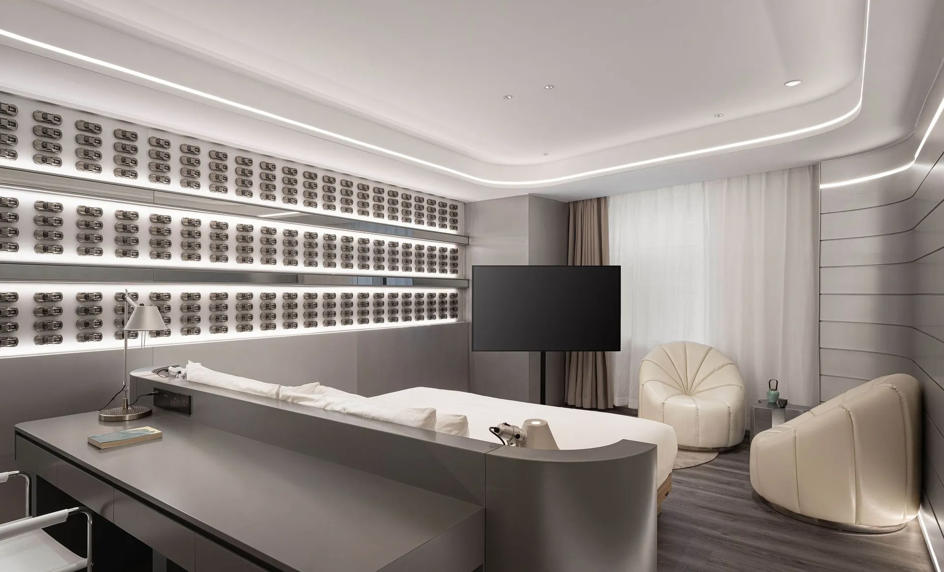 A sleek, modern hotel room featuring metallic finishes and a minimalist design.