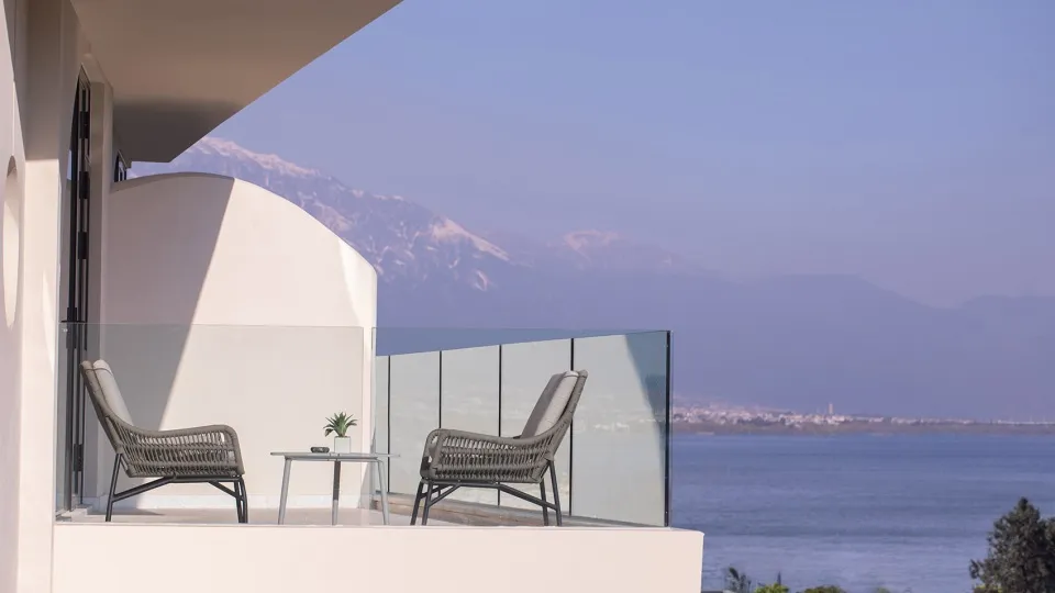 Modern vacation home with a glass balcony overlooking the sea.