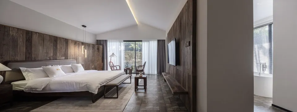 Modern bedroom interior with wooden walls, stone floor, and glass window.