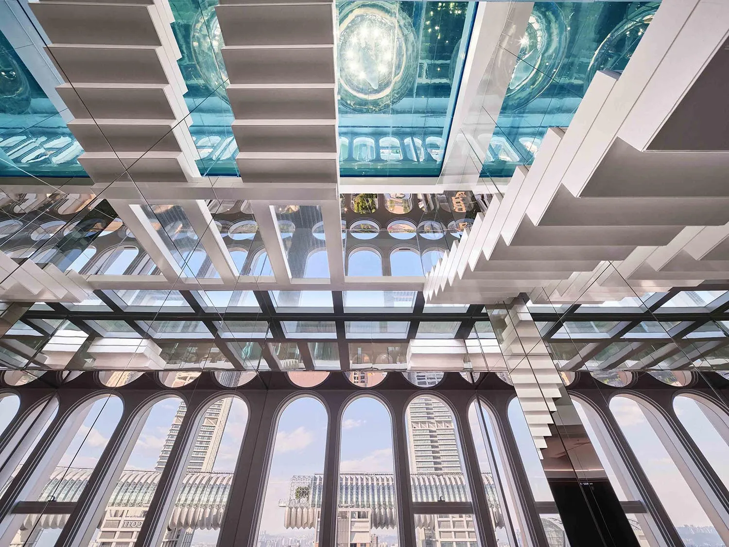 A modern interior space featuring a glass roof with intricate structural design.