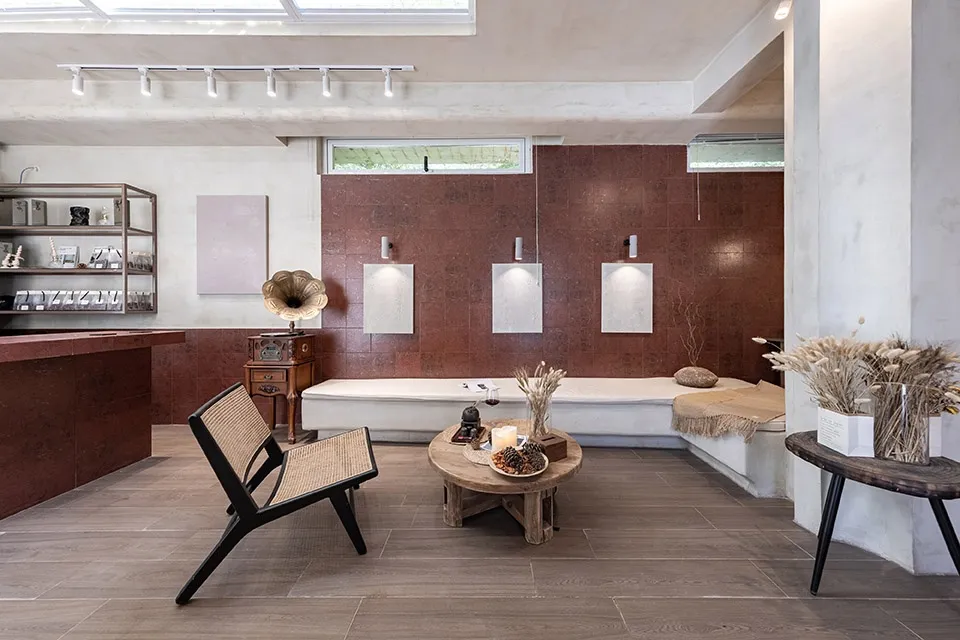 A modern retail storefront with concrete walls, minimalistic décor, and sleek furniture.