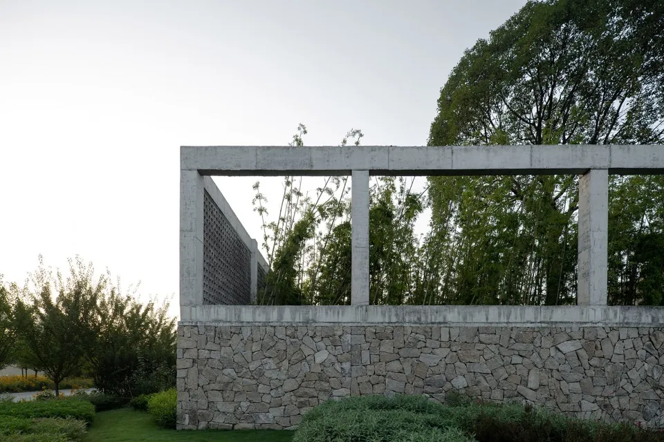 Modern concrete architectural structure with greenery in the background.