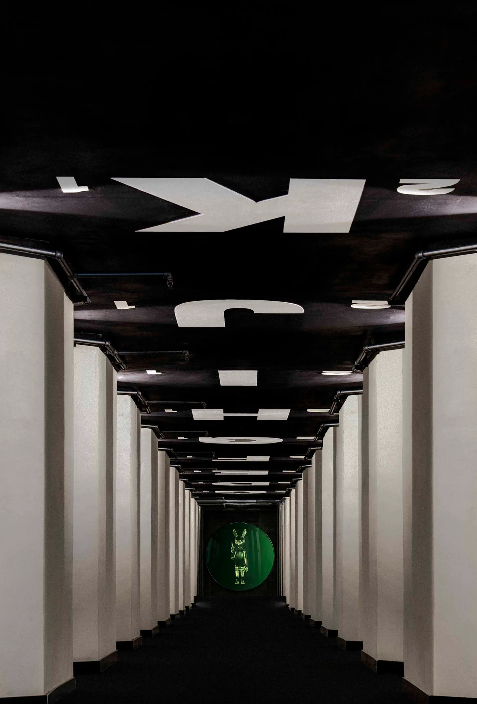 A minimalist corridor with black and white metallic elements.