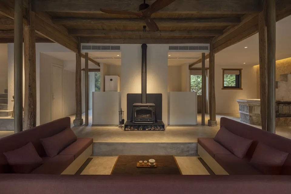 Industrial-style living space featuring concrete and wooden materials and a central fireplace.