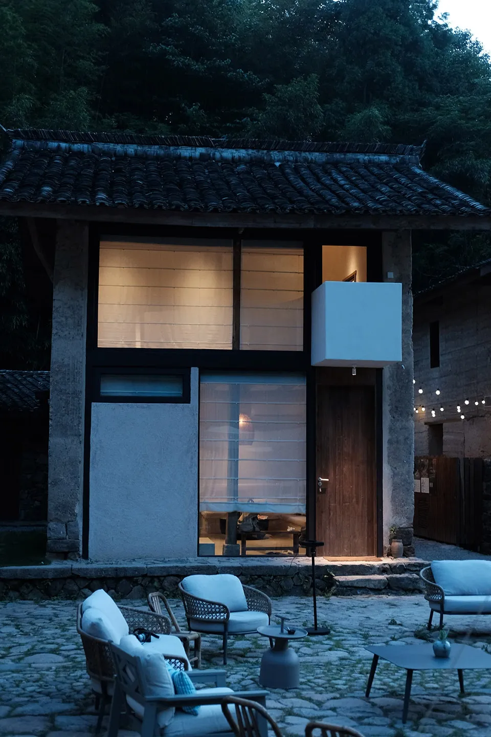 極簡住宅外觀，採用石材與木質立面，呈現乾淨俐落的現代設計，並設有小型露台