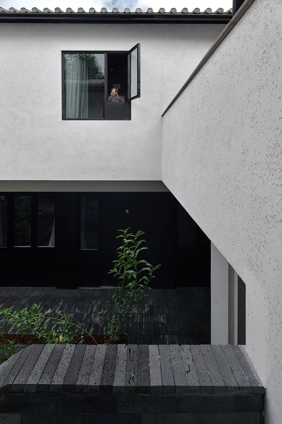 Modern minimalist residential space featuring a white wall and concrete floor.