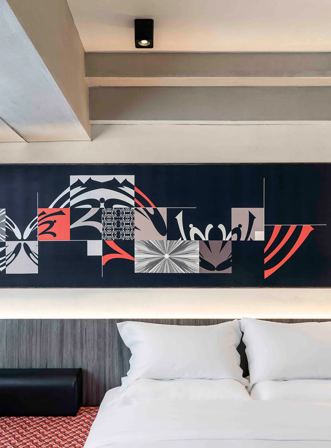 Modern bedroom design featuring a geometric textile print pattern on the headboard wall.