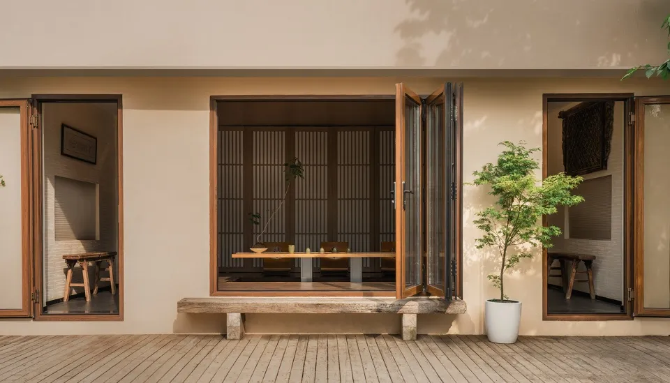 一間現代客廳,擁有木質牆面與家具,大型窗戶讓自然光灑入室內。