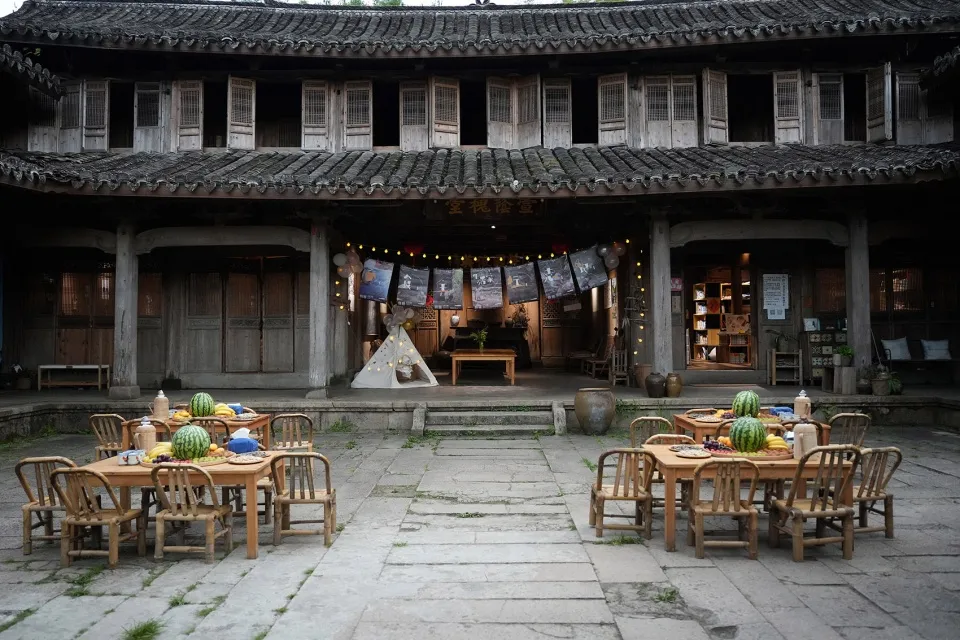 傳統中式建築前設有木製桌椅的戶外座位區，屋頂覆蓋傳統瓦片與木質結構